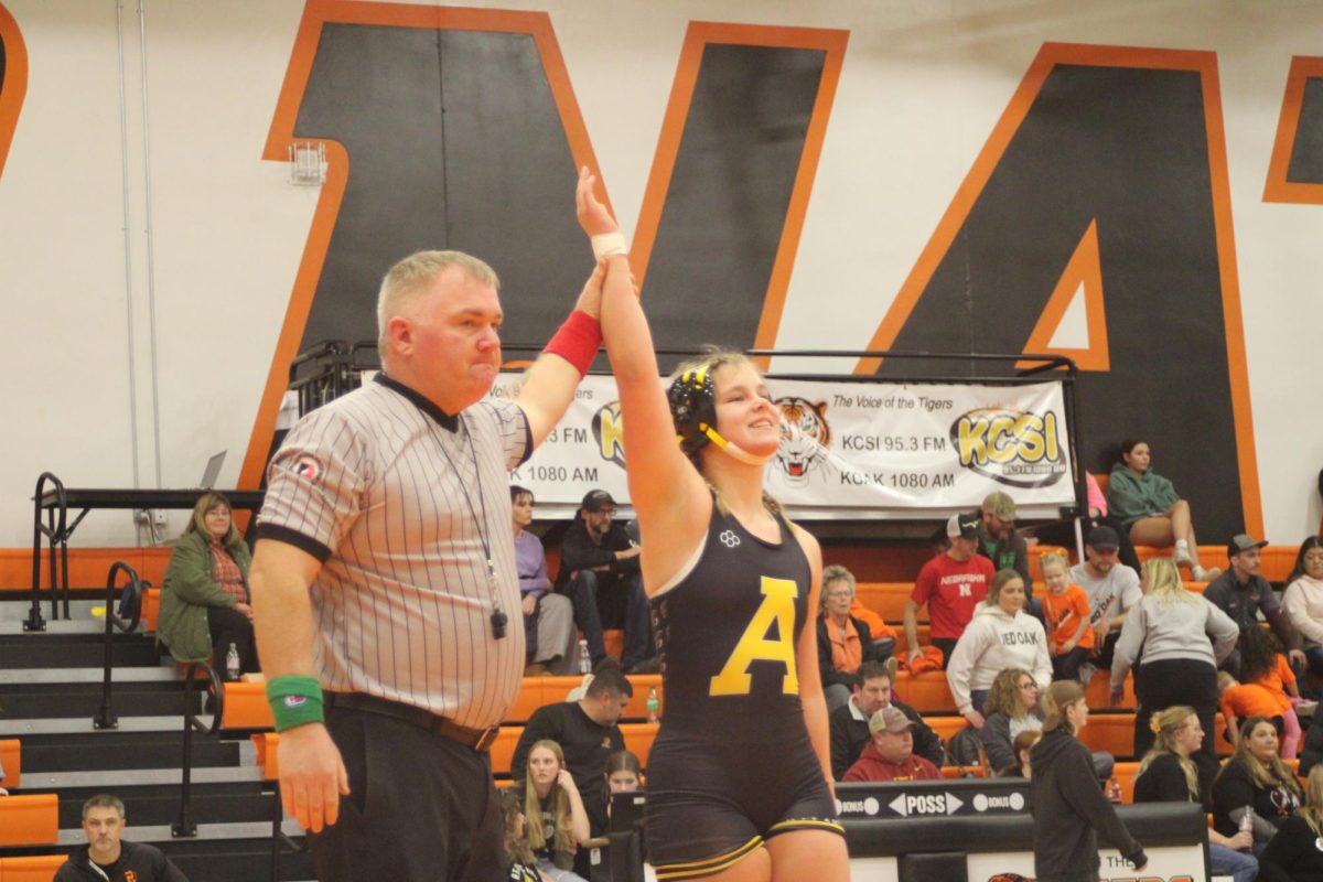 Josie MIller stands tall as the official declares her the winner. She earned the win through consistent effort and control. The match concluded with an official victory.