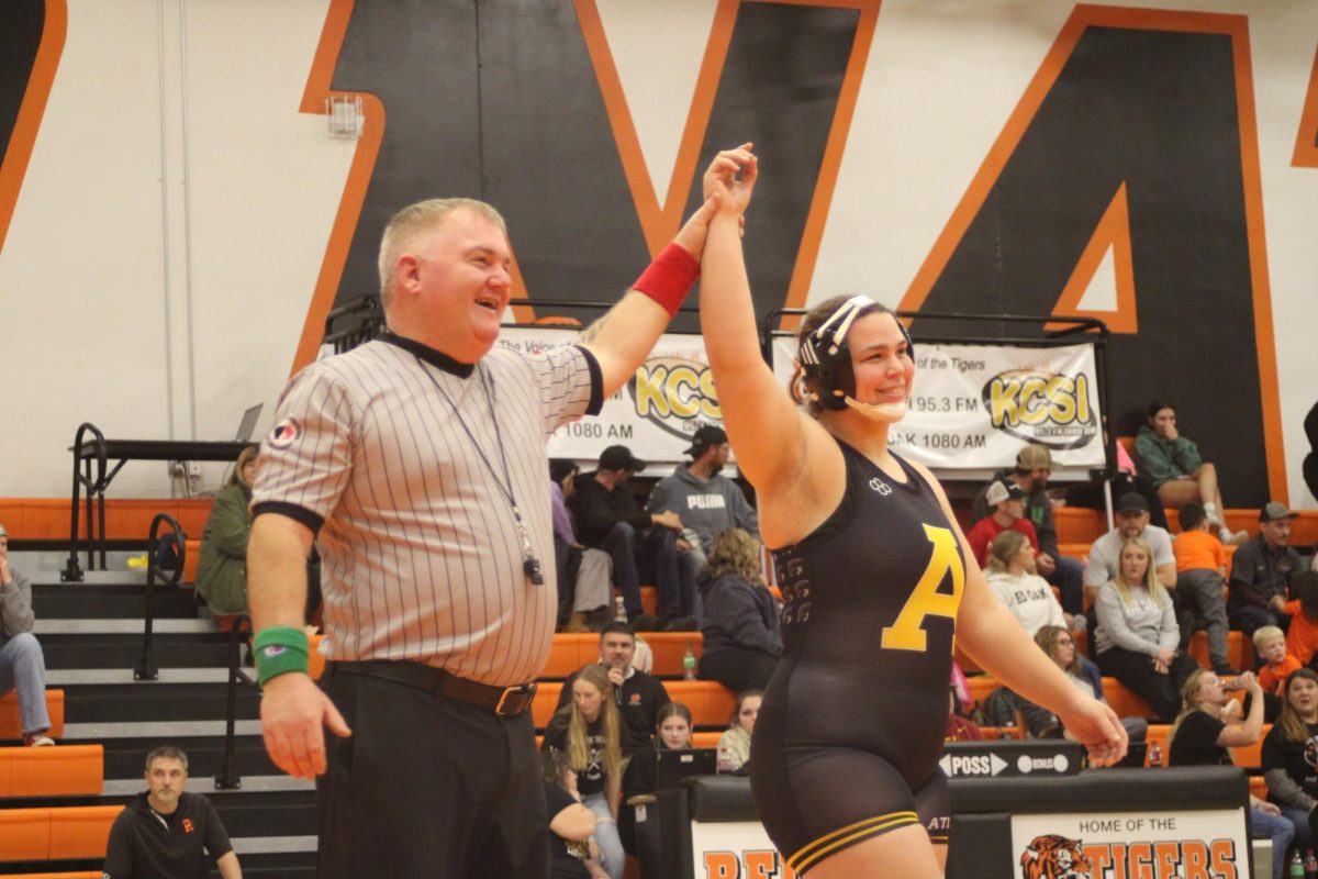 Haley Armstrong raises her hand in victory at the end of the match. She showed skill and determination throughout every period. The referee’s signal marked the end of a hard-fought battle.