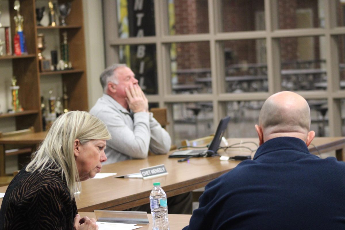 Superintendent Beth Johnson speaks with Josh McLaren at a school board meeting.