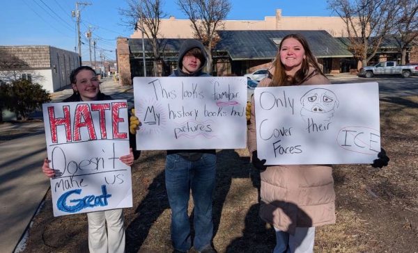 Students who participated in the walkout stand in City Park with their homemade signs. Protest organizer Bailey Grieshaber is pictured furthest to the right.