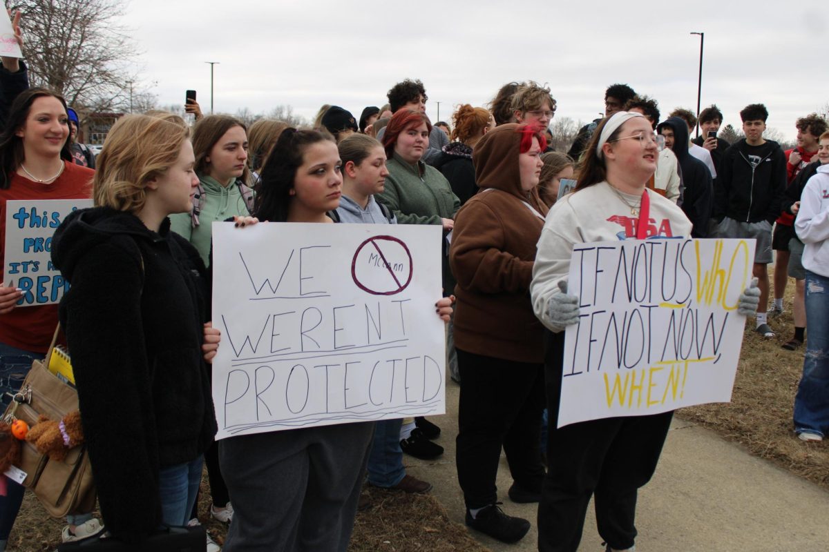 Students stand at the Feb. 6 walkout. Students for Justice organizer Hope Mathis is on the right with the sign.