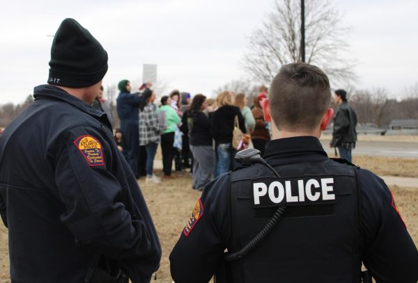 Two police officers look on during the Feb. 6 "Fire McCann" walk out.