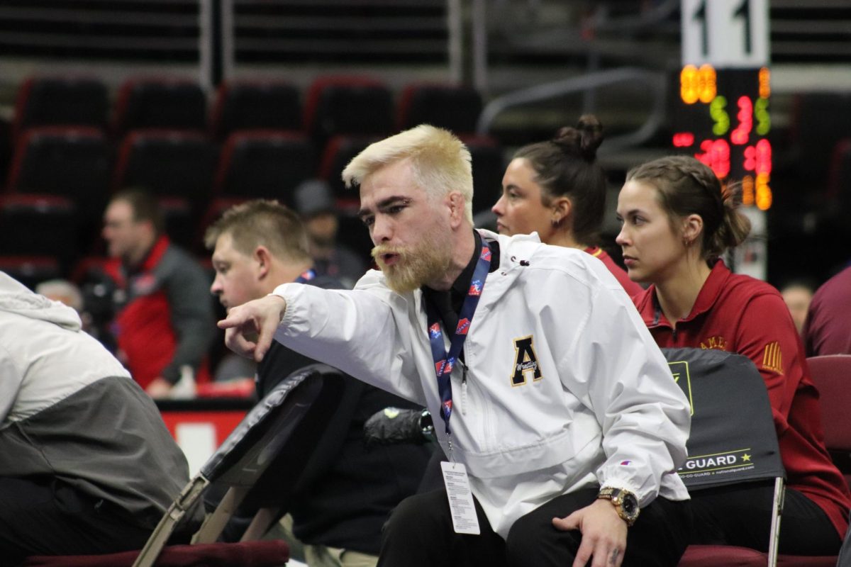 Assistant coach Dylin Cox points for the referee to see that Dayton Van Horn has earned a takedown. Cox was a wrestler for Atlantic during his high school years and came back to assist with the wrestling program. He also helps run the local Ace wrestling club to continue building the Atlantic wrestling program.