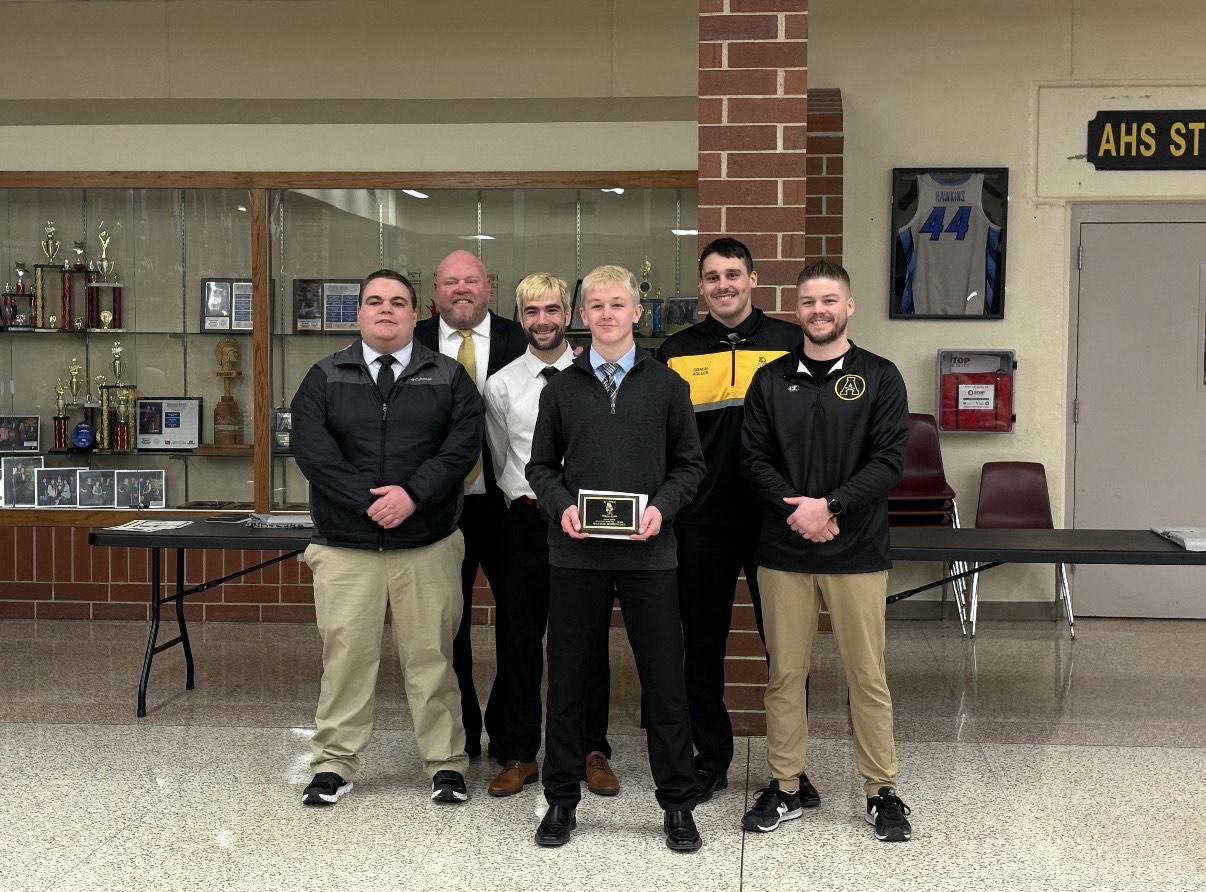 Sophomore Keaton Schroeder stands in front of the coaching staff to receive his hustle award.