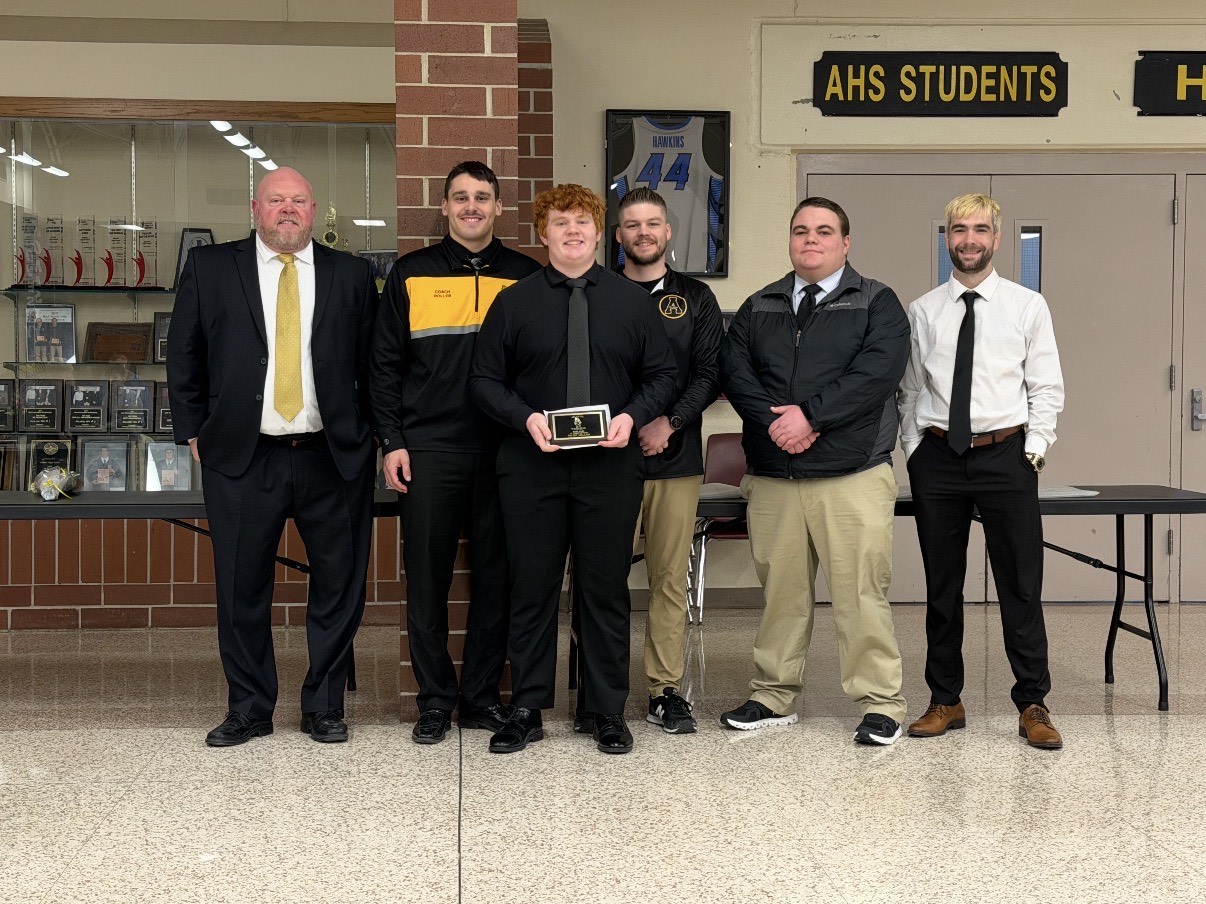 Sophomore Owen Miller stands in front of the coaching staff to receive his award.