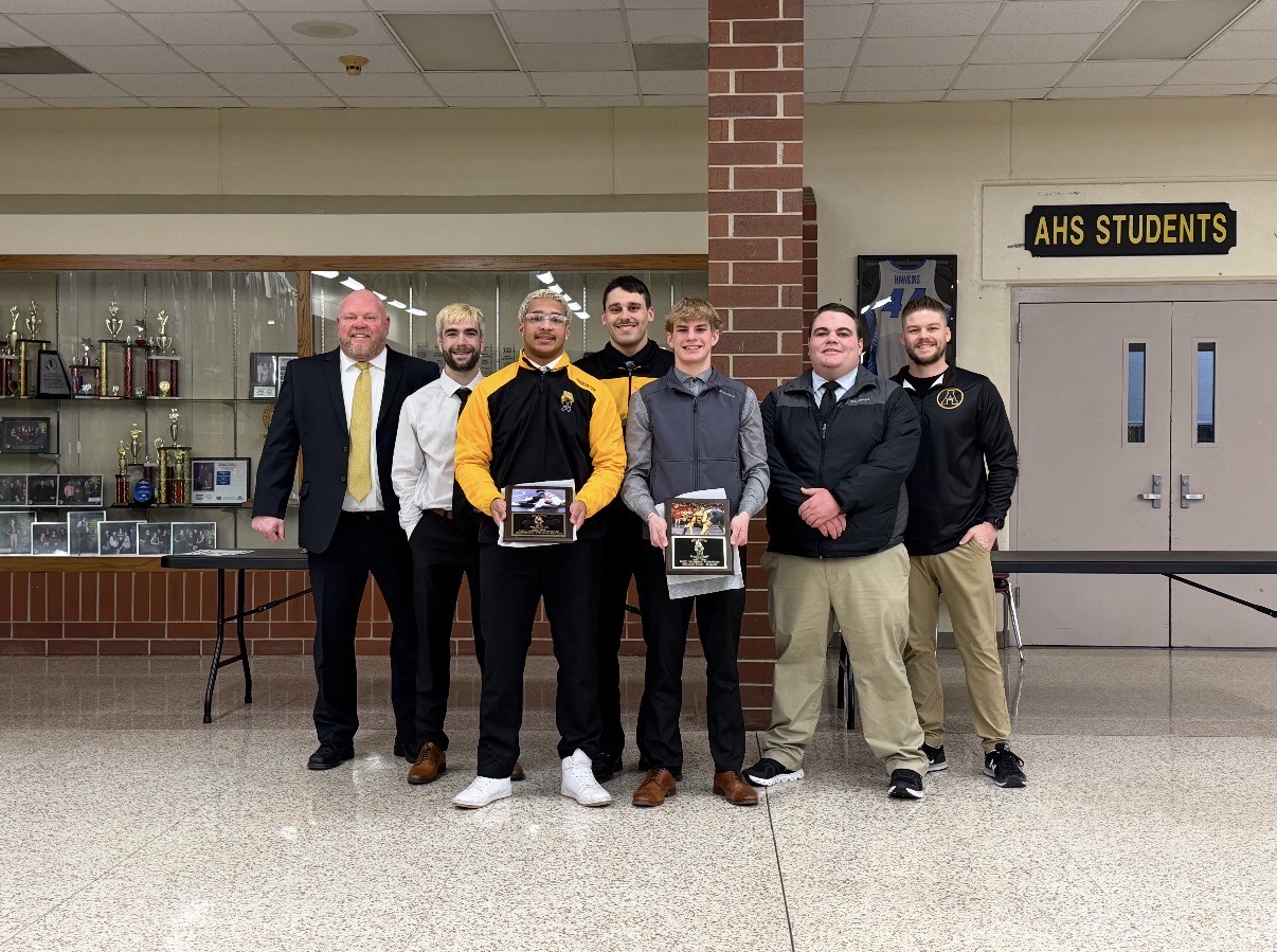 Seniors Donovan Hedrington and Braxton Hass stand in front of the coaching staff to receive their award.