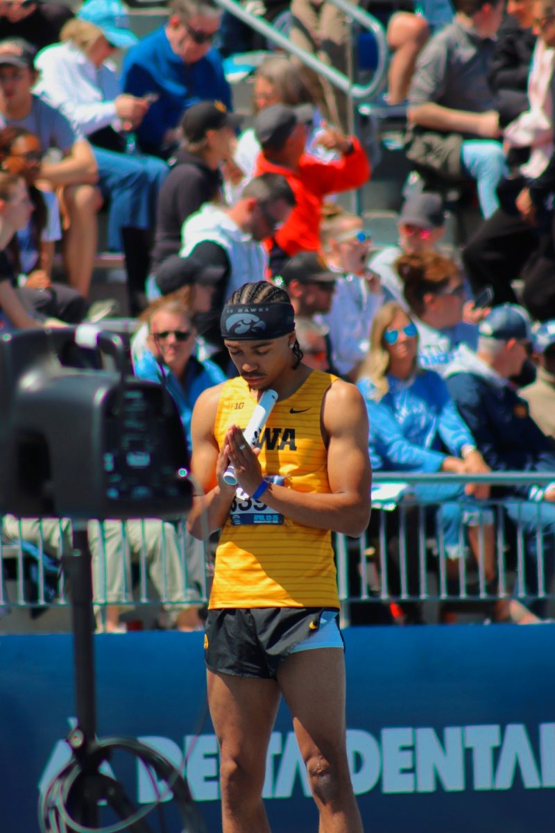 University of Iowa athlete praying before competing in a race at the Drake Relays. 