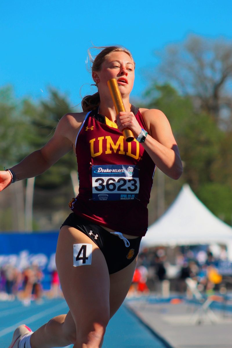 Athlete out for breath as she crosses the finish line after her teams race. 