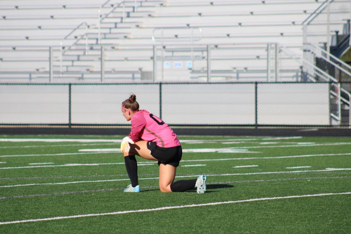 Goalkeeper Clara Kennedy takes a knee as a teamate is helped off the field after an on field collision. 