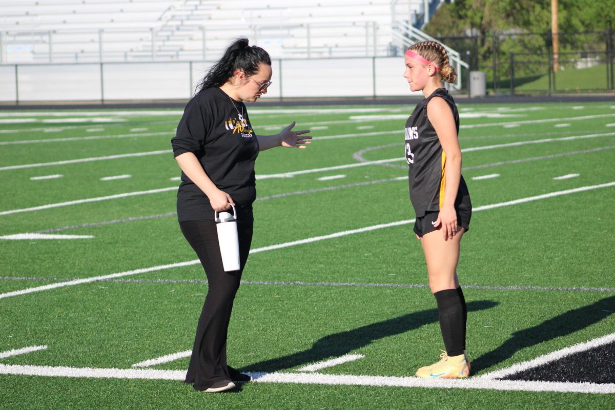 Head Coach Amy Sachs instructs midfielder Chloe Lillard during halftime.