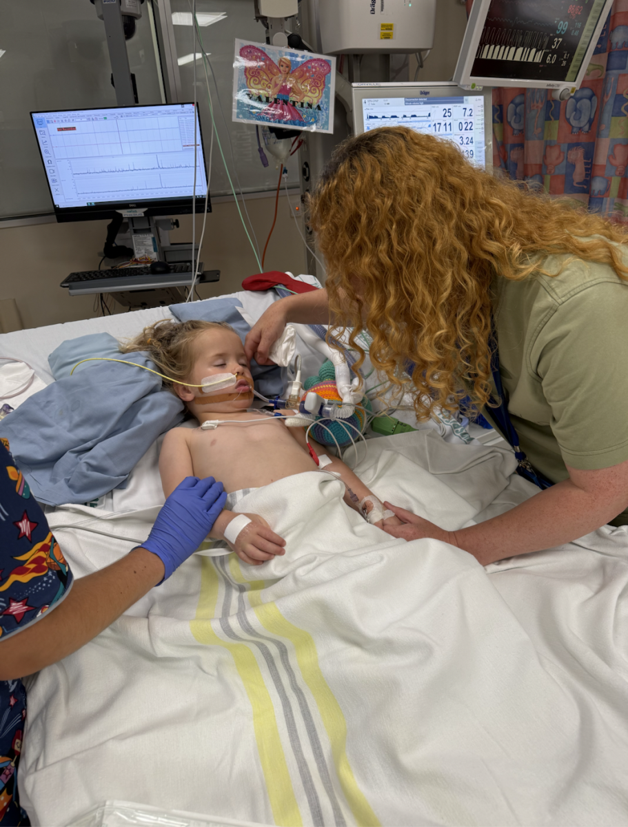 Andrea Hoegh offers soft touches to her daughter Valentina, who is resting on a cooling mat to prevent brain swelling.