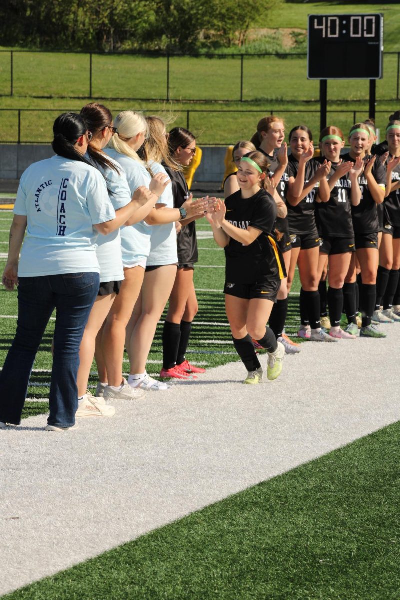 Freshman Henley Coffman high fives her teammates during the opening procession.