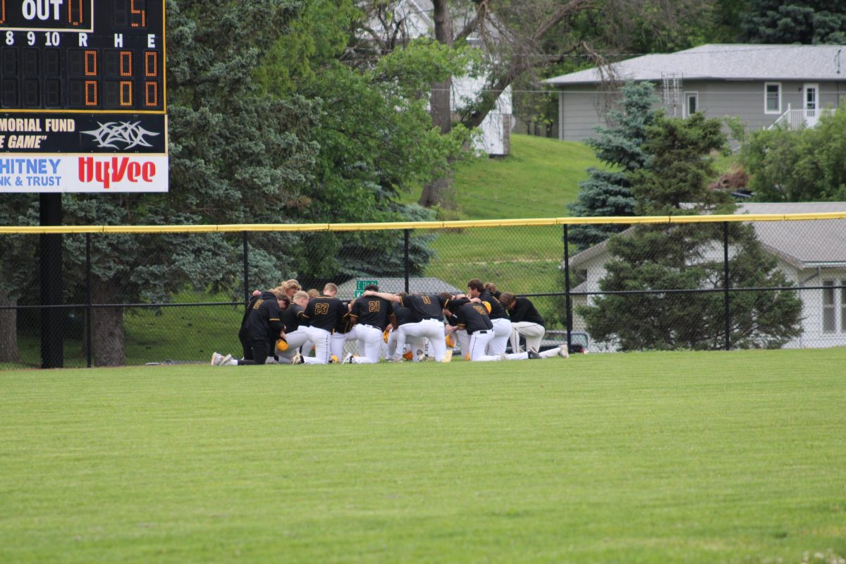 The baseball team is in a huddle before the game. 
