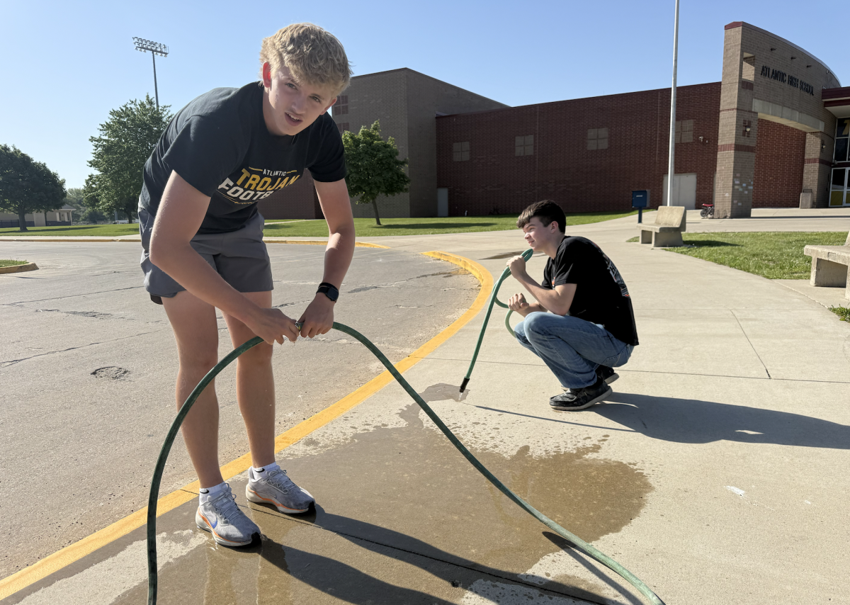 "We are trying to spiff it up for commencement on Sunday," says Grant Petty. Grant Petty and Brody Erickson work on attaching hoses to water the plants. As FFA Vice President and a student in the Horticulture class, Petty  strives to make our school "prettier."