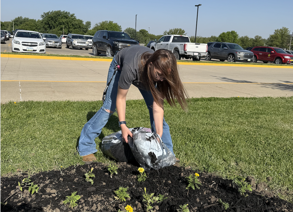 Teagan Daniels lays out mulch for some flowers. In front of the Atlantic High School, the Horticulture class planted flowers for the upcoming graduation. Graduation takes place on May 17th, the next Sunday.