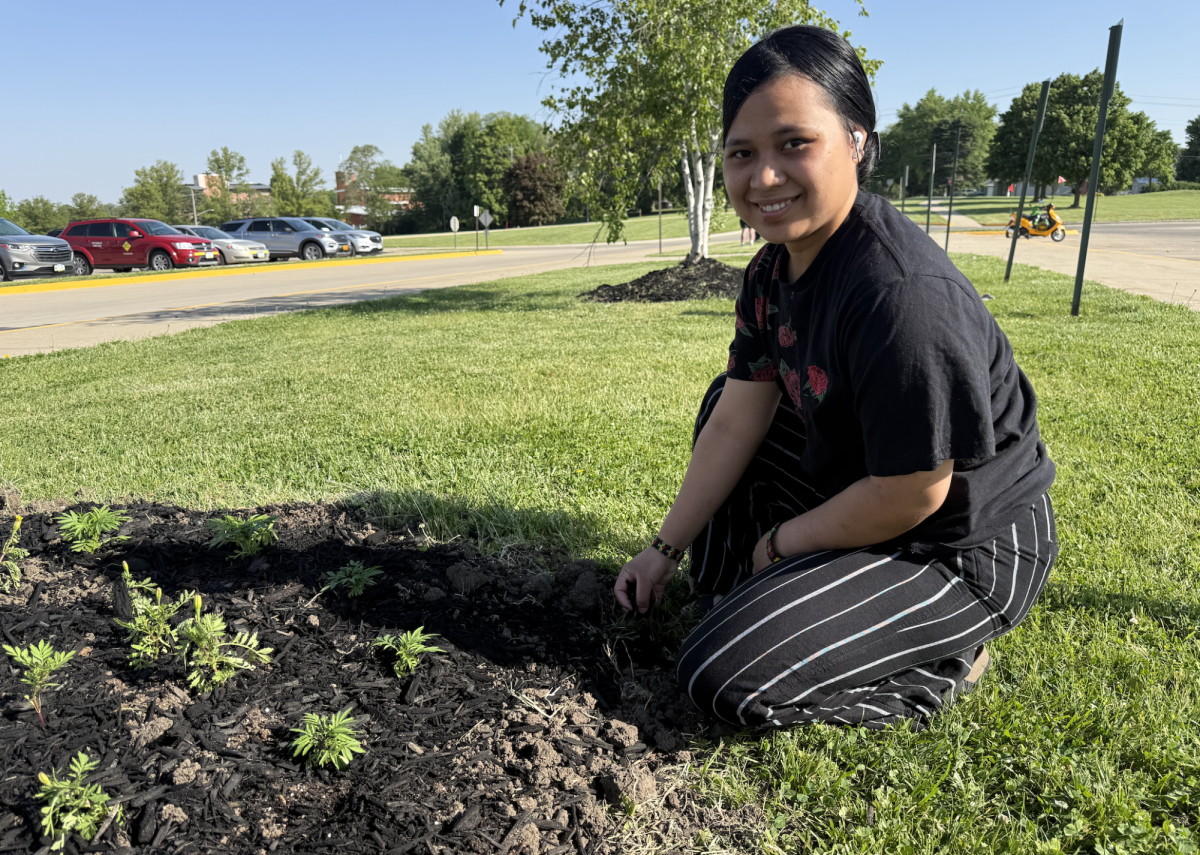 Jessica Martin plants flowers in front of the school. Along with the mulch, she helped grow these plants in the greenhouse. She plans to help take care of the flowers until school is out.