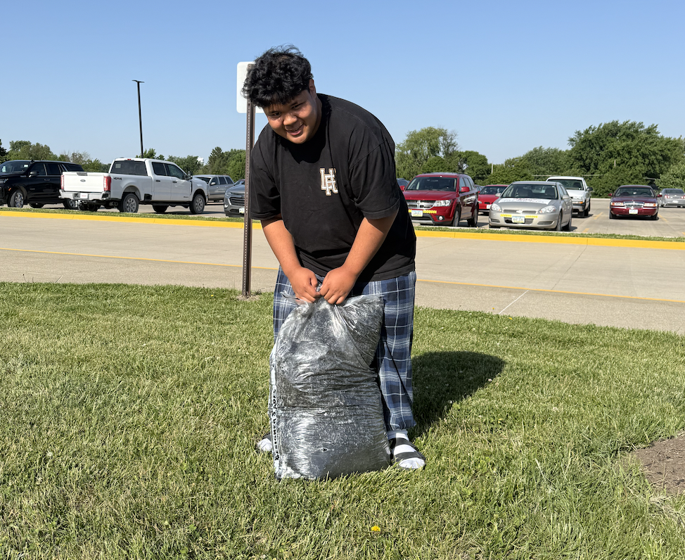 Truman Yamaguchi opens a bag of mulch. Yamaguchi spread mulch over all four gardening sites